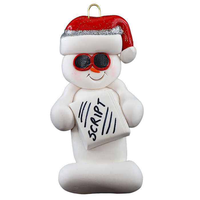 Ornament of white snowman in red hat and sunglasses holding a movie script.