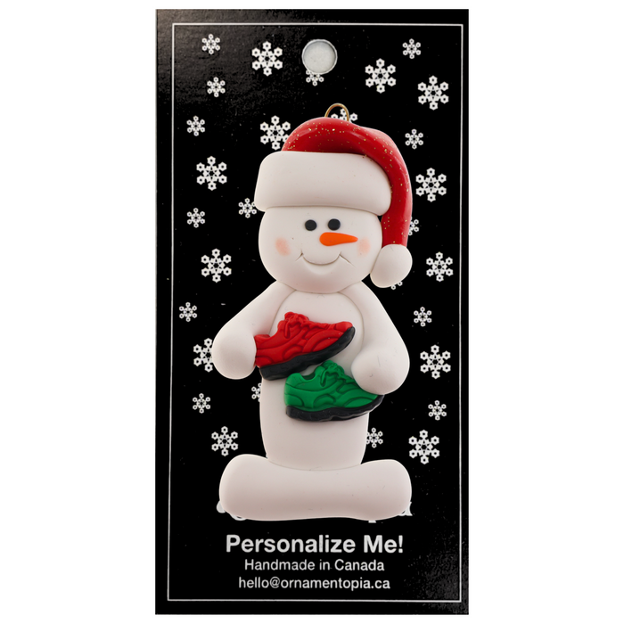 Snowman in red hat with running shoes, on display backing card.