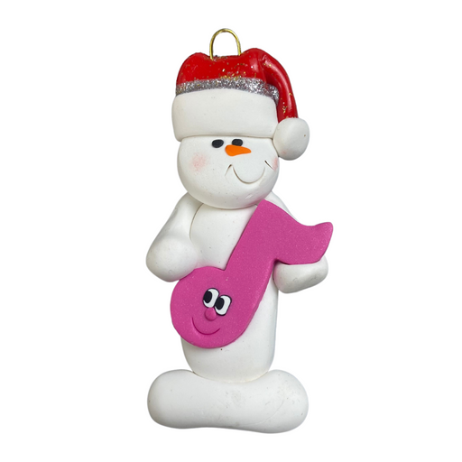 Ornament of white snowman in red hat holding a pink music note.