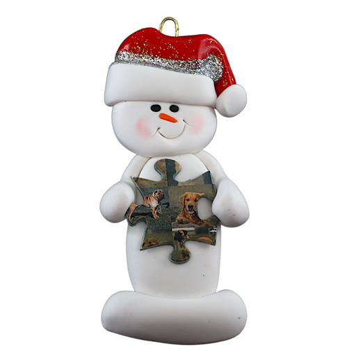 Ornament of white snowman in red hat holding a puzzle piece.