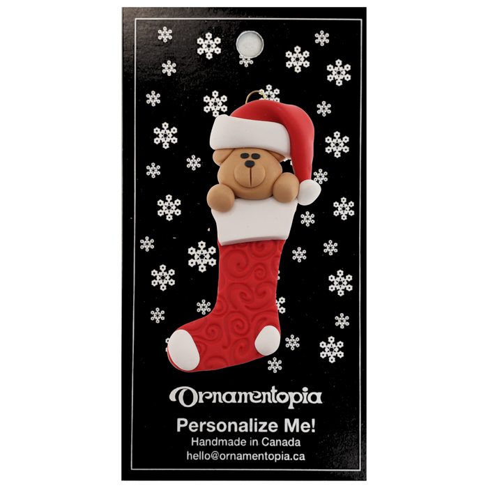 Ornament of bear head poking out of a red stocking, on display backing card.