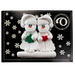 Family ornament with 2 white snowmen in hats, holding holiday objects, on display backing card.