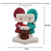 Ornament of snowman couple in red and green shirts and hats with brown dog in Christmas hat, graphed to show size (7x10cm).