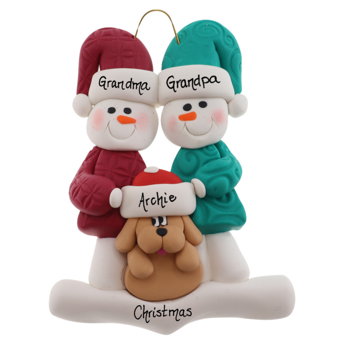 Ornament of snowman couple in red and green shirts and hats with tan dog in Christmas hat, personalized with names.