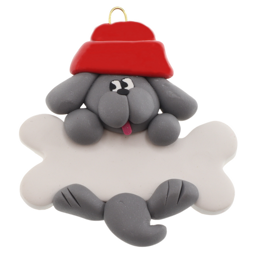 Ornament of grey dog in red hat hanging on a white bone.