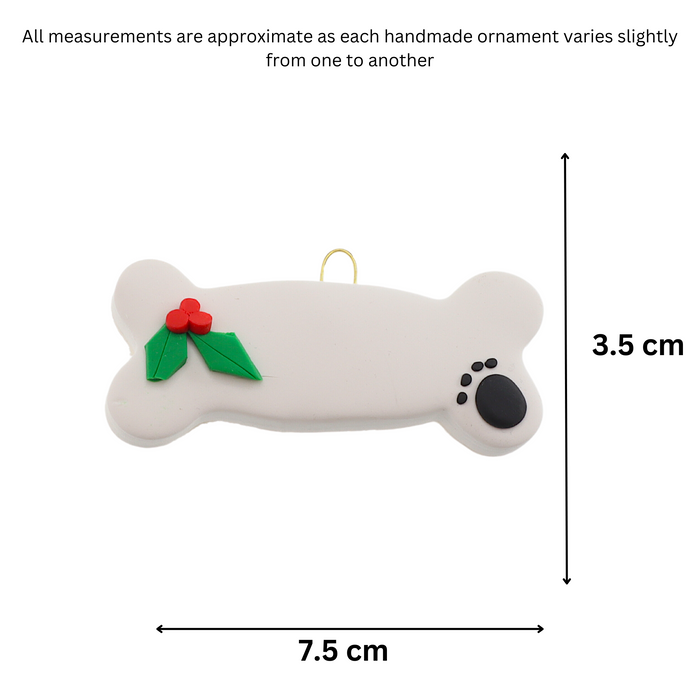 Ornament of dog bone with holly and paw print, graphed to show size (7.5x3.5cm).