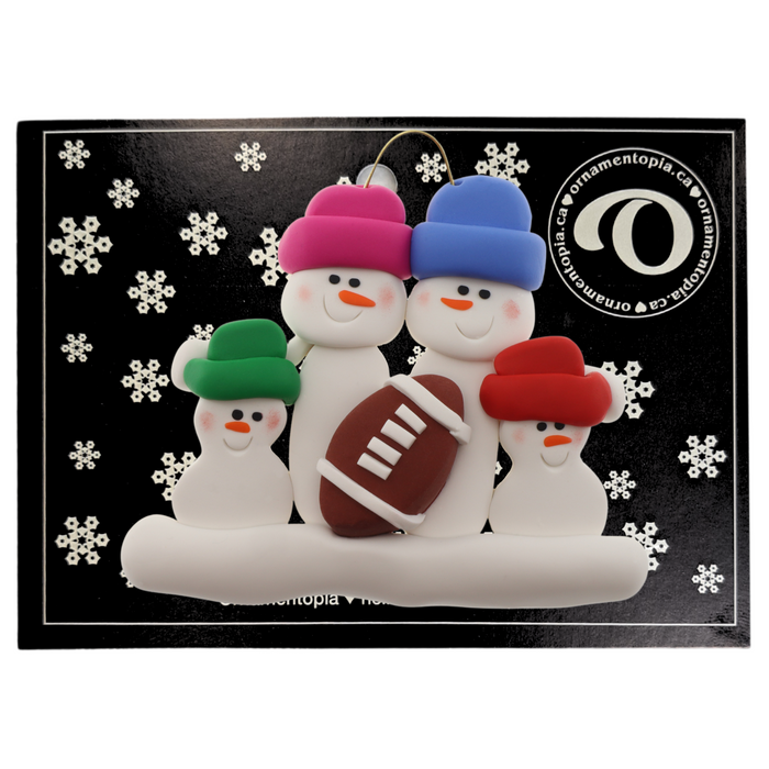 Family ornament with 4 white snowmen in bright hats with a football, on display backing card.