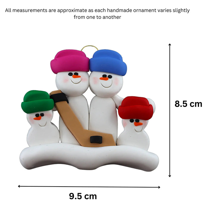 Family ornament with 4 white snowmen in bright hats, holding a hockey stick, graphed to show size (9.5x8.5cm).