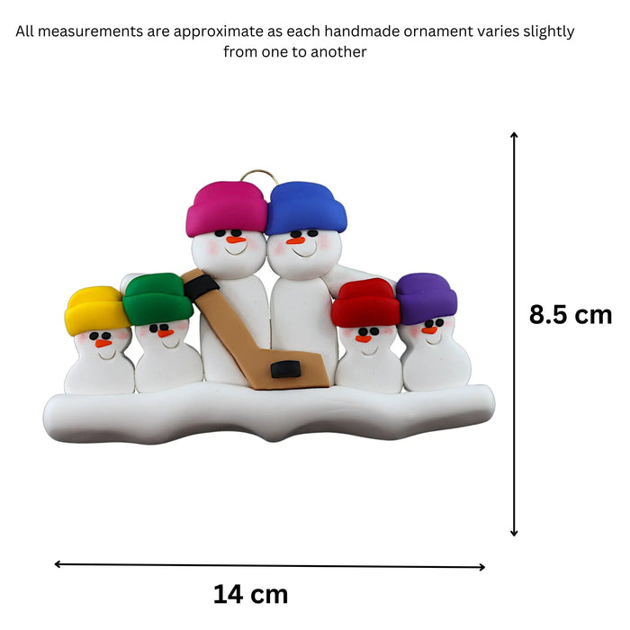Family ornament with 6 white snowmen in bright hats, holding a hockey stick, graphed to show size (14x8.5cm).