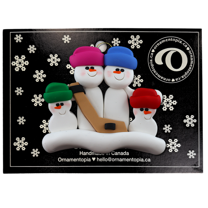 Family ornament with 4 white snowmen in bright hats, holding a hockey stick, on display backing card.