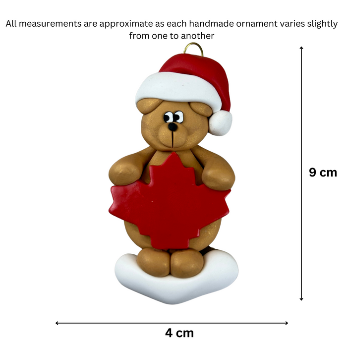 Tan bear in red festive hat with maple leaf ornament, graphed to show size (4x9cm).