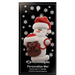 Ornament of white snowman in red hat holding a brown dog on a leash, on display backing card.