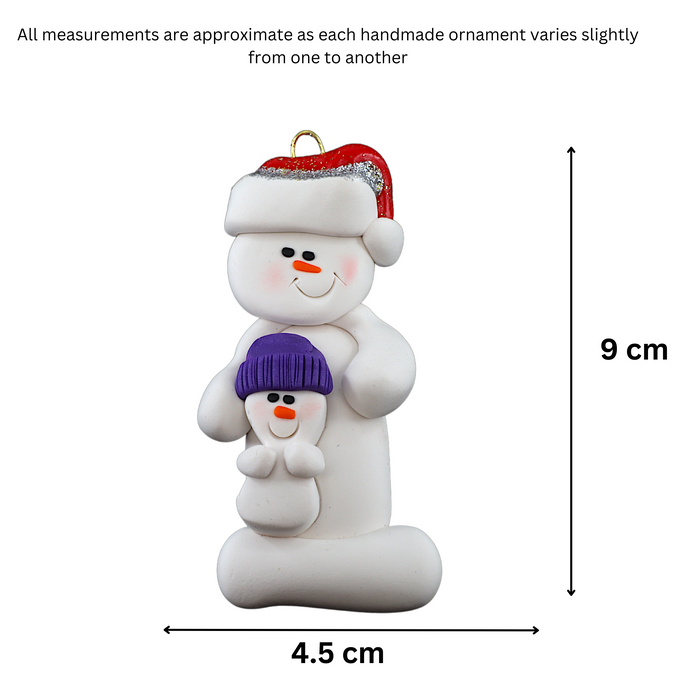 Ornament of white snowman in red hat holding smaller snowman, graphed to show size (4.5x9cm).