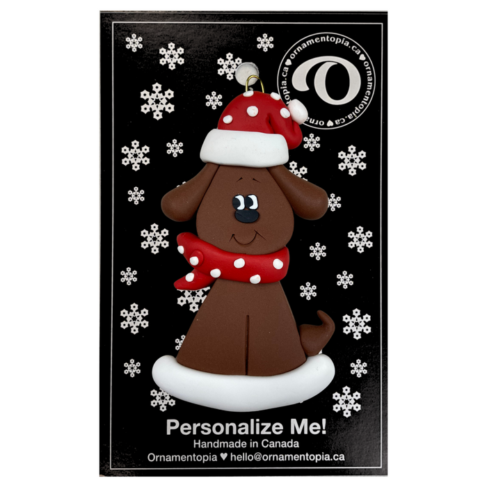 Ornament of brown dog in a red and white polka dot Christmas hat and scarf, on display backing card.