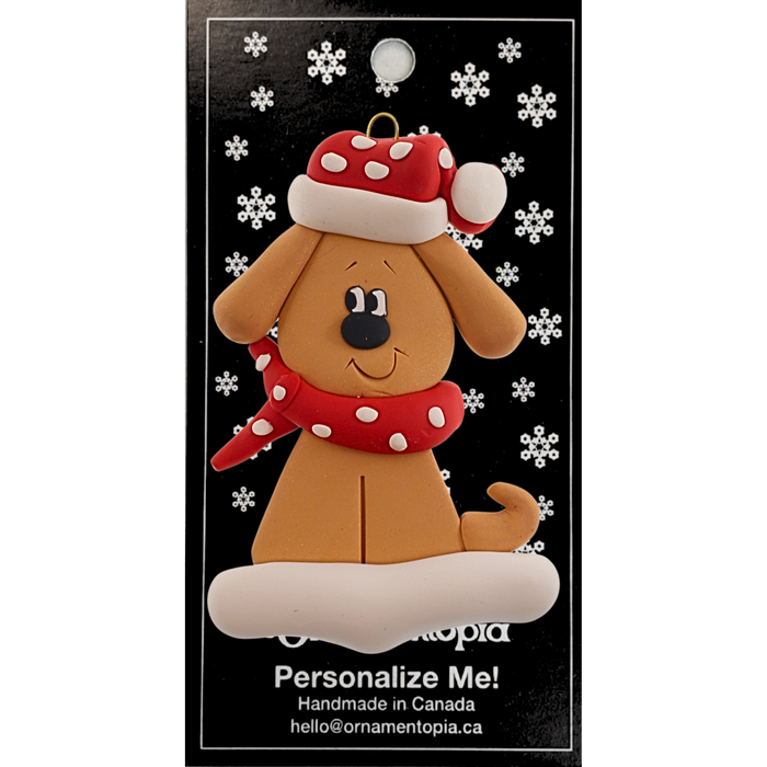 Ornament of tan dog in a red and white polka dot Christmas hat and scarf, on display backing card.