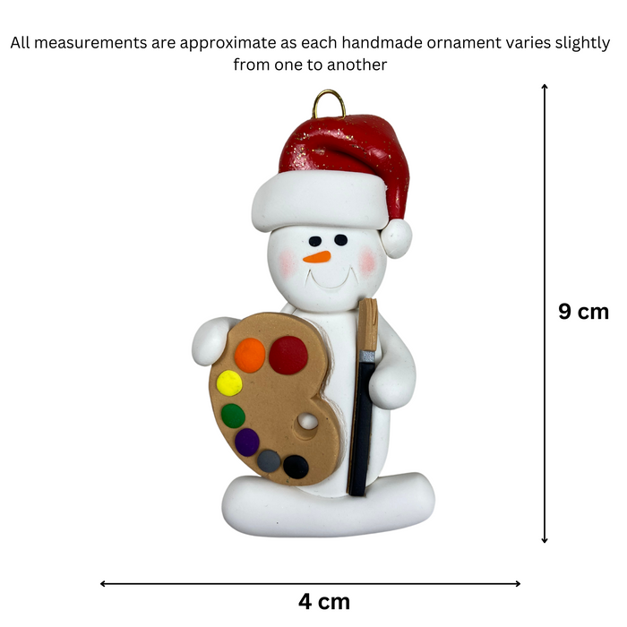 Ornament of white snowman in red hat holding a paint palette and paintbrush, graphed to show size (4x9cm).