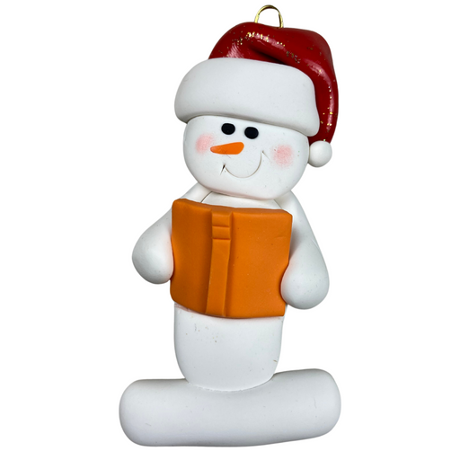 Ornament of white snowman in red hat holding an orange book.