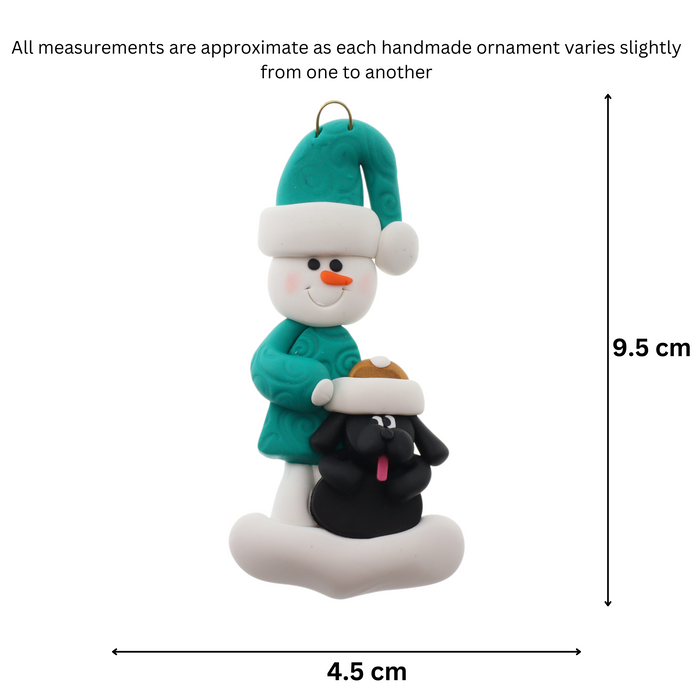 Ornament of snowman in green shirt and hat with black dog in Christmas hat, graphed to show size (4.5x9.5cm).