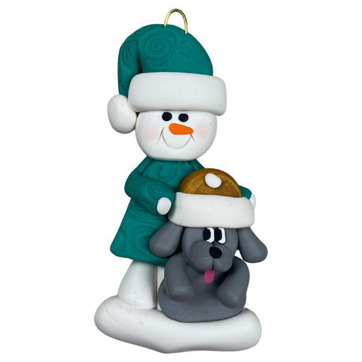 Ornament of snowman in green shirt and hat with grey dog in Christmas hat.