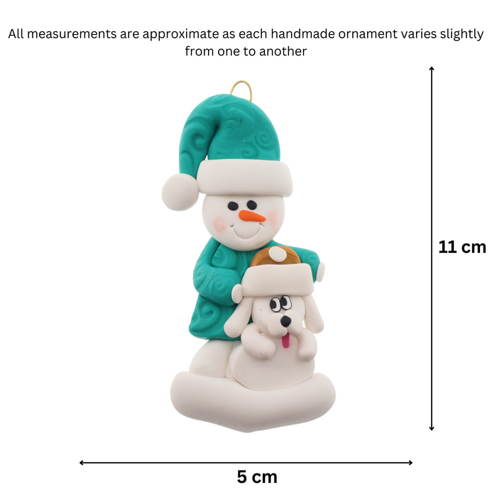 Ornament of snowman in green shirt and hat with white dog in Christmas hat, graphed to show size (5x11cm).