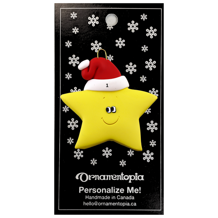 Yellow star in red Christmas hat ornament, on display backing card.